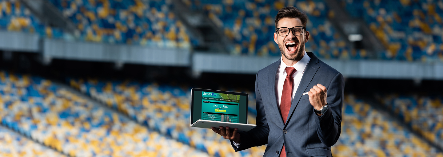 excited man with a laptop showing and increase in first time deposits
